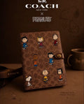 Agenda Coach x Peanuts con monograma y personajes Snoopy Charlie Brown Lucy